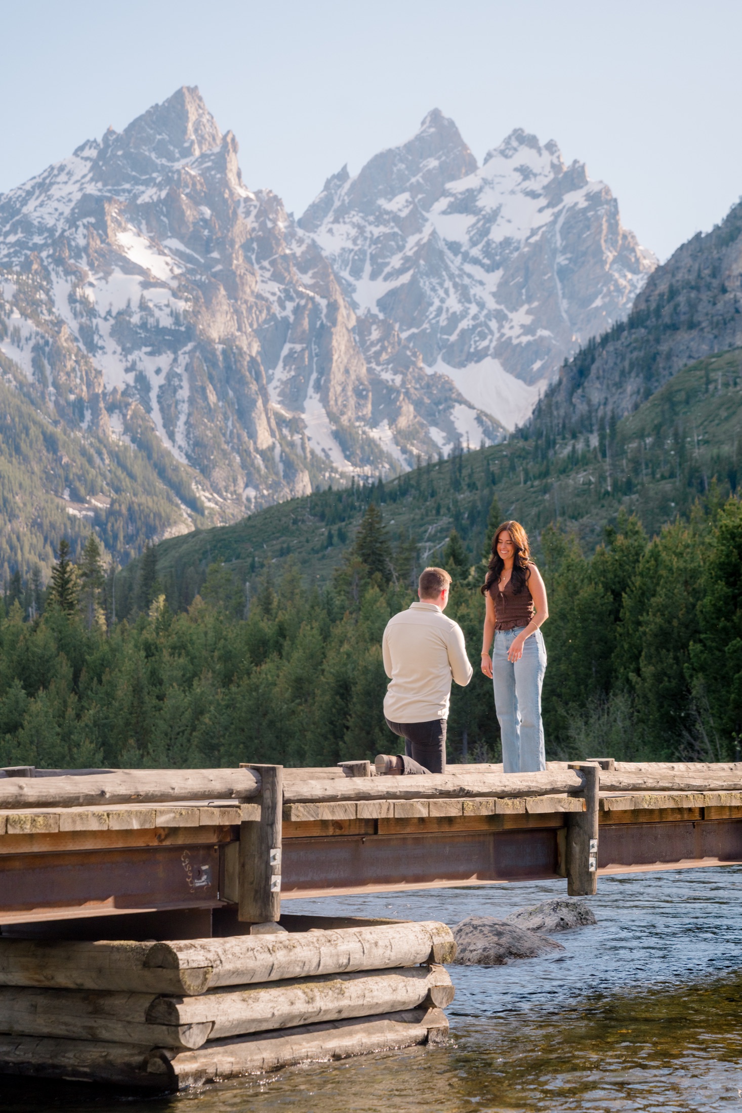 Michael proposing to Brooke on a bridge in the mountains