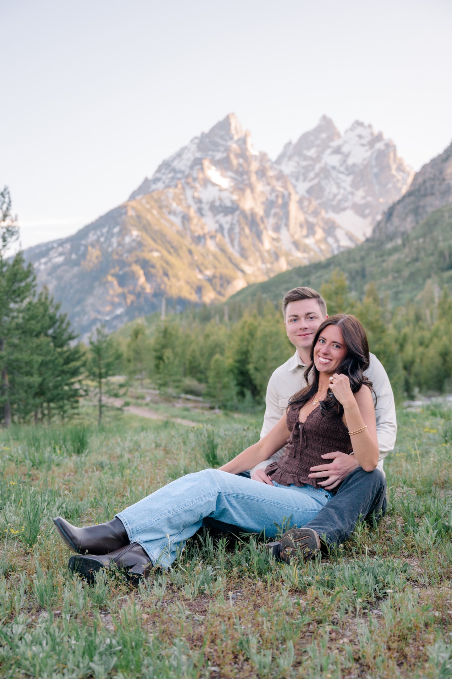 Michael and Brooke sitting together in a mountain meadow