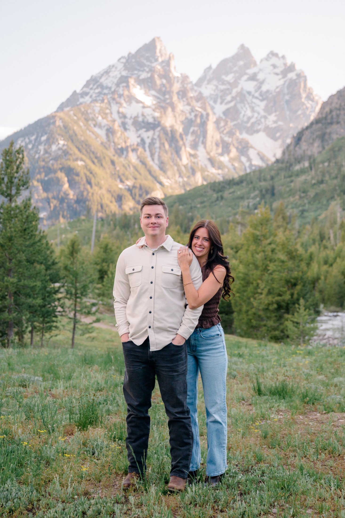 Michael and Brooke smiling together with the Tetons behind them