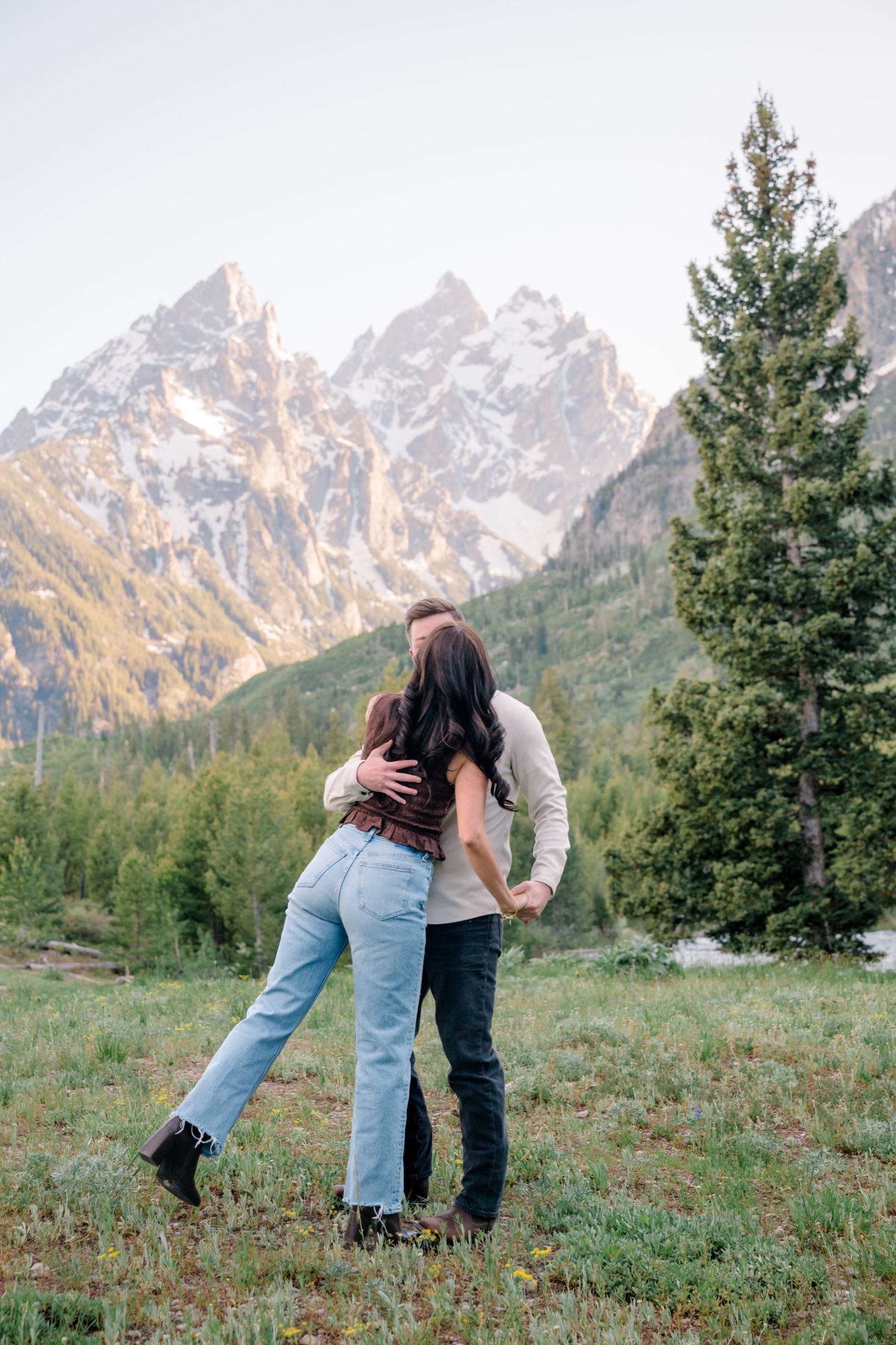 Michael and Brooke kissing in front of the mountains